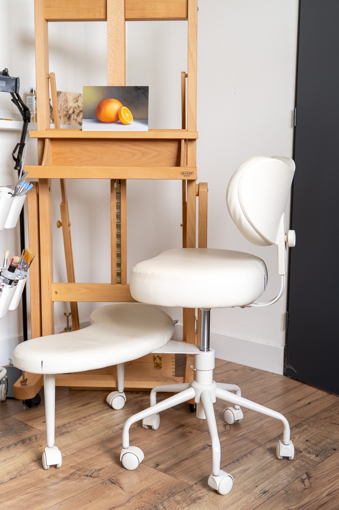 painting set up with a chair and an orange still life painting